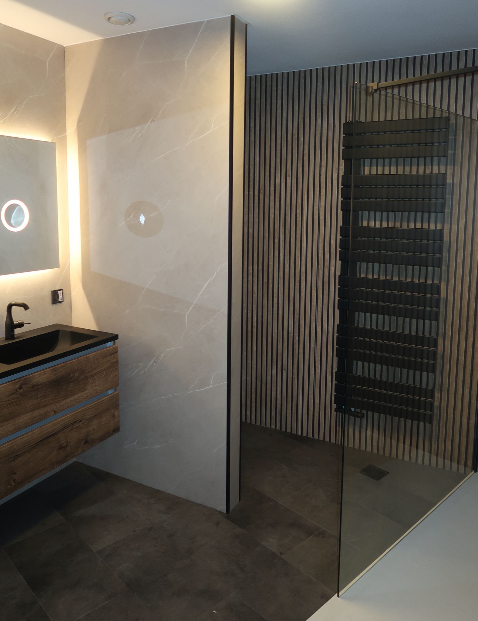 Overzicht van moderne badkamer met houtlook accenten, inloopdouche en wastafelmeubel