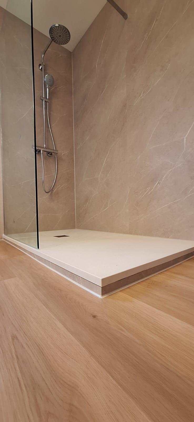 Beige marmerlook inloopdouche met houtlook vloer en glazen wand