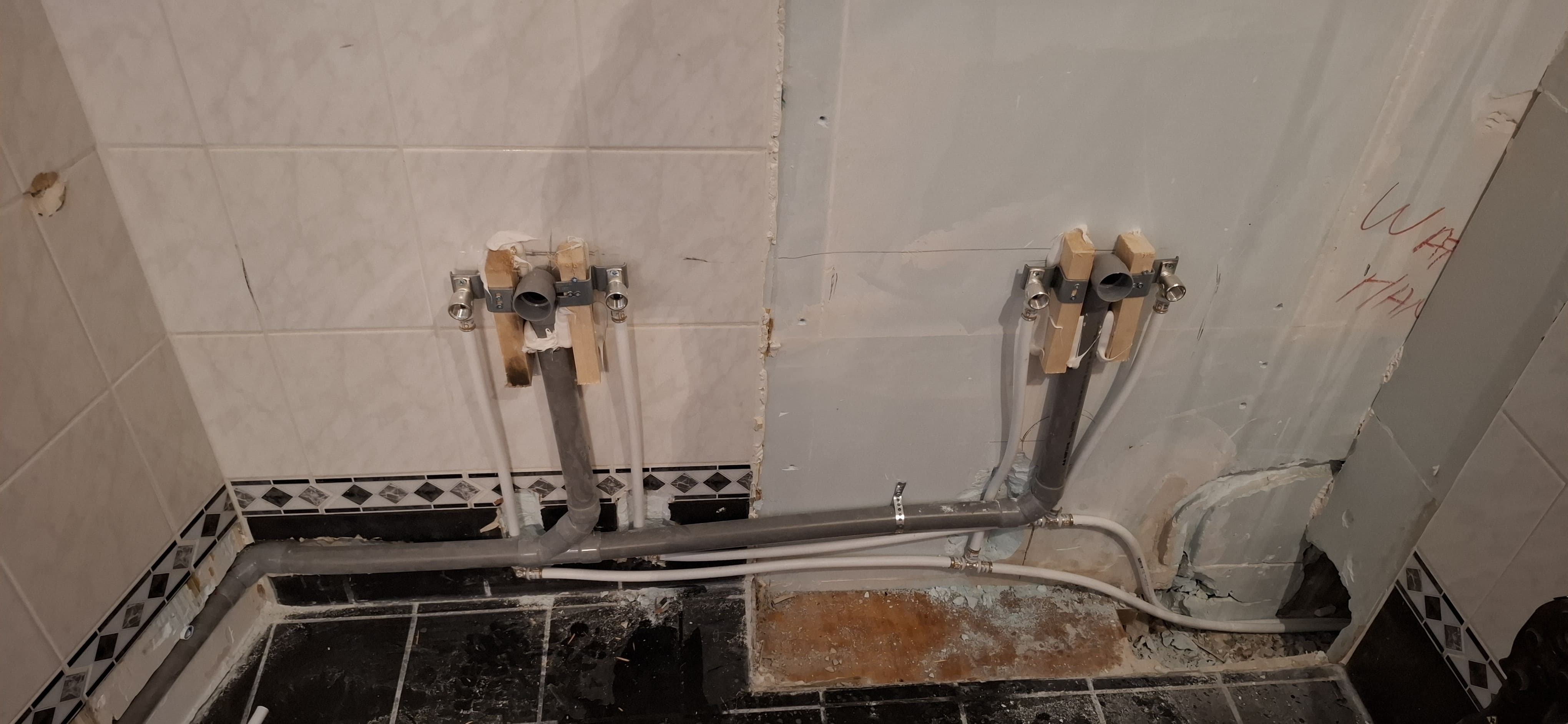 Badkamerrenovatie in uitvoering: waterleidingen en afvoerleidingen worden opnieuw aangelegd.